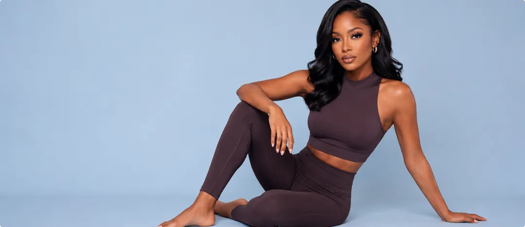 Model in a brown set against a periwinkle backdrop — DIY lash look